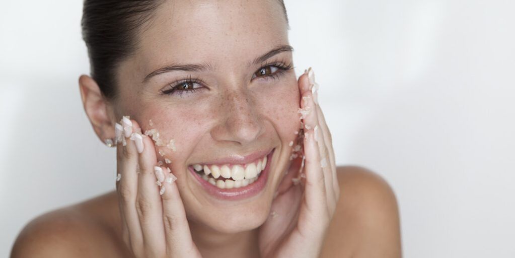 The girl prepares the skin for rejuvenation at home using scrubbing